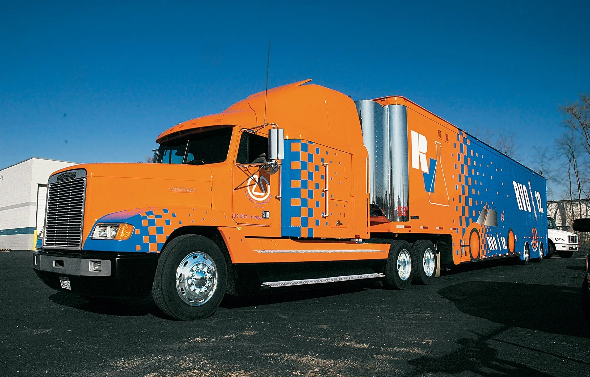 Semi tractor-trailer with an orange and blue wrap